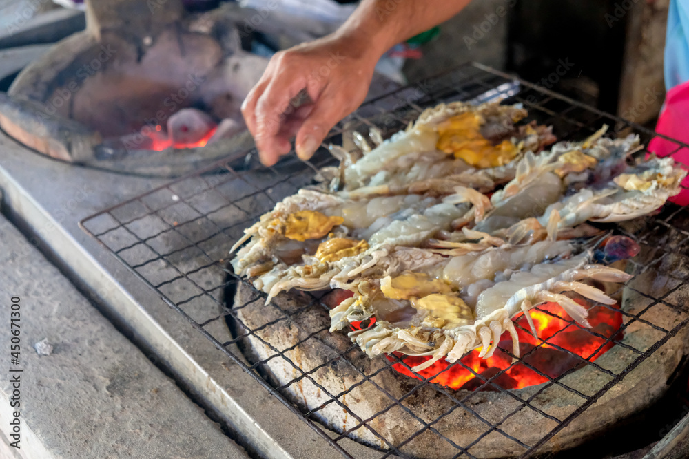 Grilled Giant River Prawns On Fire. Photo of cook by grilling shrimp with Charcoal  in Traditional Thai style.