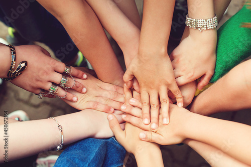 Sign of trustful friendship. Top view group of children stacking hands outdoors.