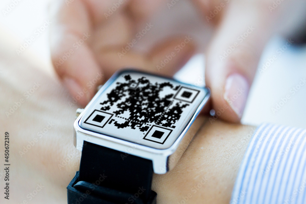 Fototapeta premium technology and health care concept - close up of woman's hands with qr code on smart watch at office