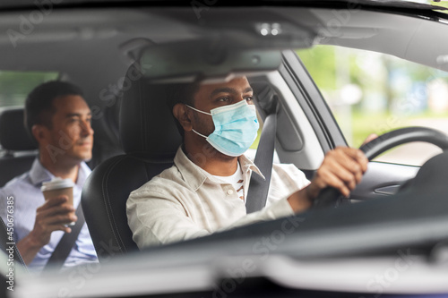 transportation, health and people concept - indian male taxi driver driving car with passenger wearing face protective medical mask for protection from virus disease © Syda Productions