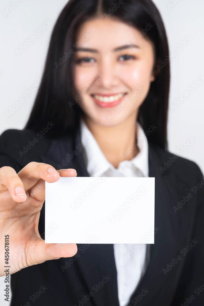 business Asian woman in black suit holding and showing empty blank business card or blank name card - business concept business Asian woman in black suit holding and showing empty blank business card or blank name card - business concept