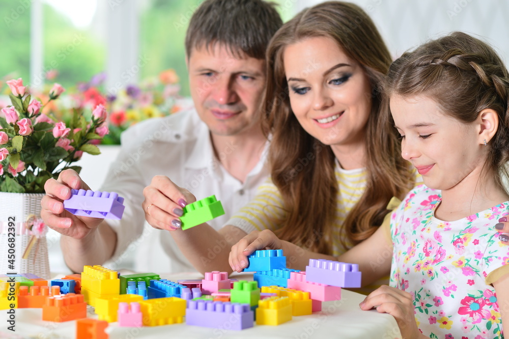 girl with mother and father playing with colorful plastic blocks girl with mother and father playing with colorful plastic blocks