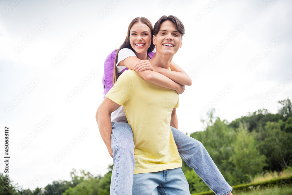 Photo of two fooling playful brother sister wear casual clothes backpack walking riding back smiling outdoors countryside Photo of two fooling playful brother sister wear casual clothes backpack walking riding back smiling outdoors countryside