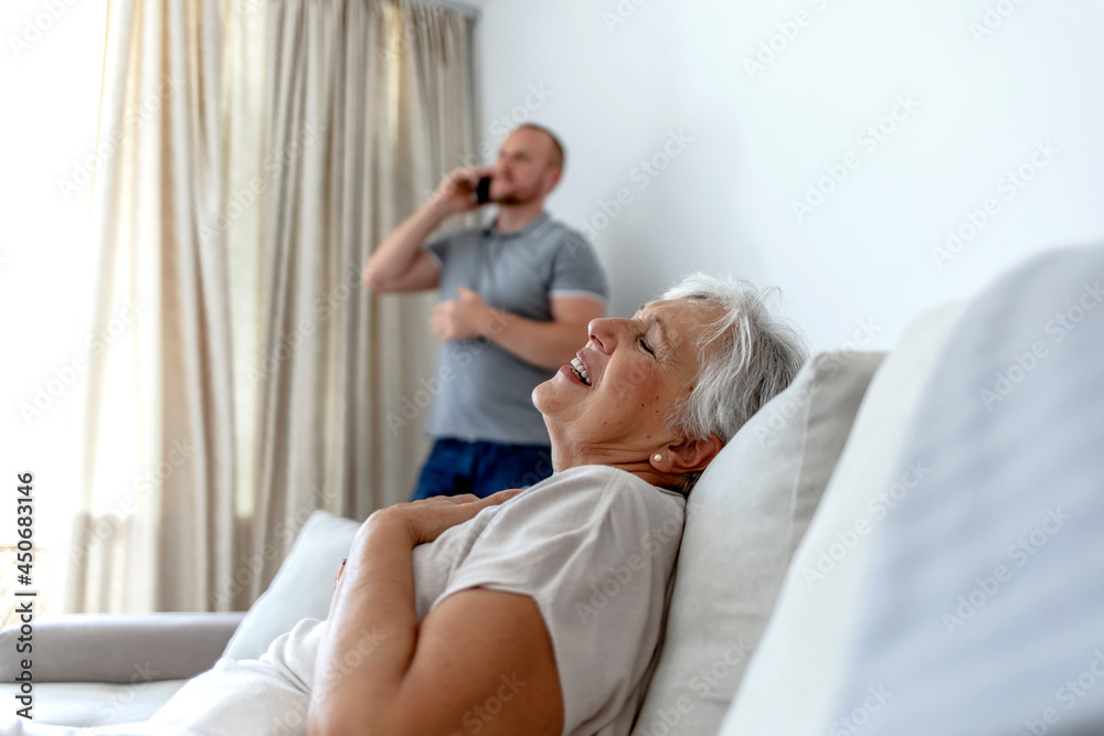 Anxious young man calling emergency, ask help for woman having heart attack. Worried male speak with 911 saving sick senior grandma suffering from coronary disease. Old woman experiencing chest pain Anxious young man calling emergency, ask help for woman having heart attack. Worried male speak with 911 saving sick senior grandma suffering from coronary disease. Old woman experiencing chest pain