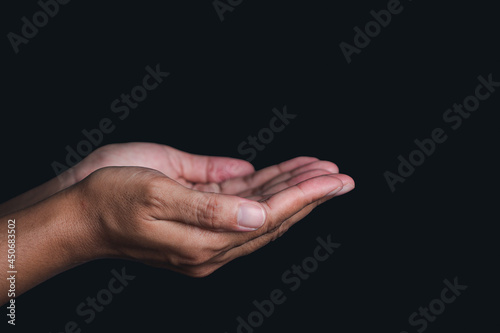 Hands isolated on black background. Hands concept. Outstretched hand. Side view. Dark background