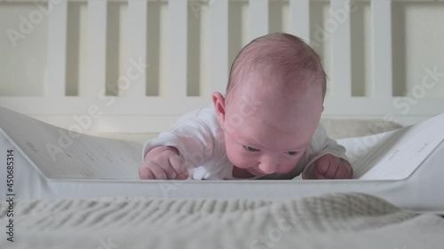 Wallpaper Mural A baby aged 1 month learns to keep his head lying on his stomach. Caucasian boy child in a home white bedroom Torontodigital.ca