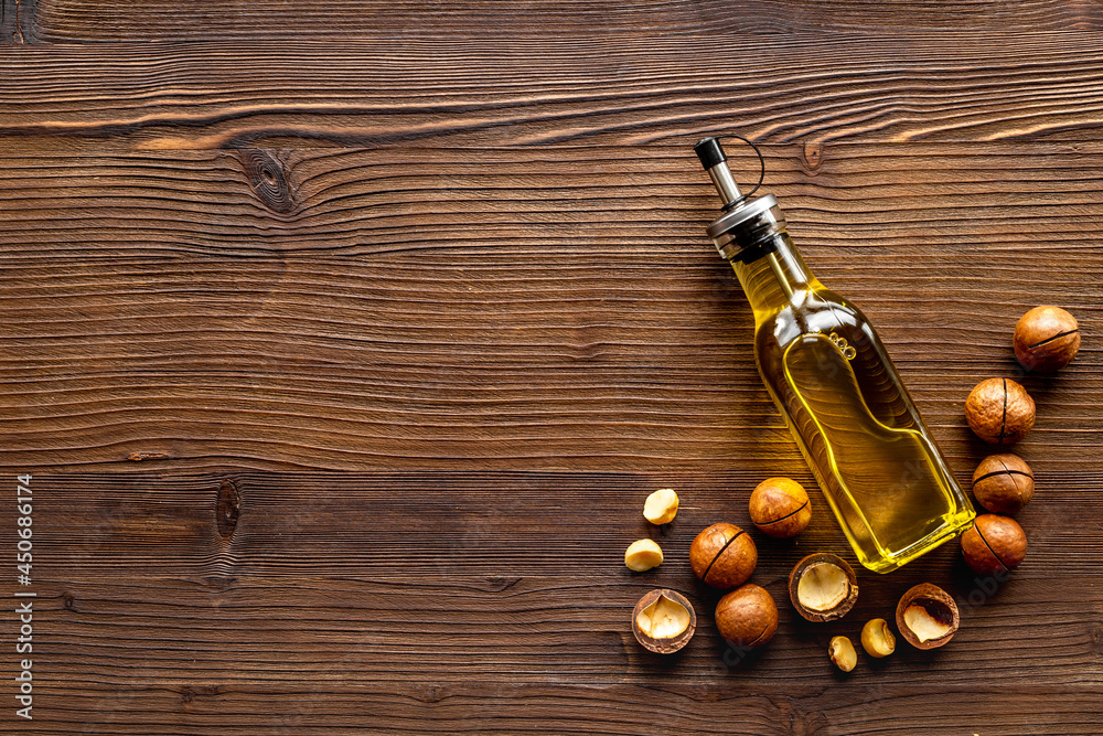 Macadamia nut oil in glass bottle with nuts. Essence extra virgin oil for food or cosmetic
