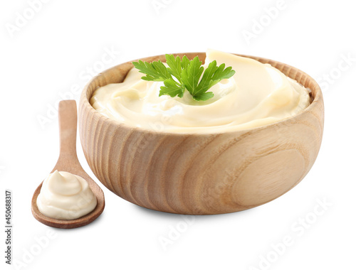 Spoon and bowl of delicious mayonnaise with parsley on white background