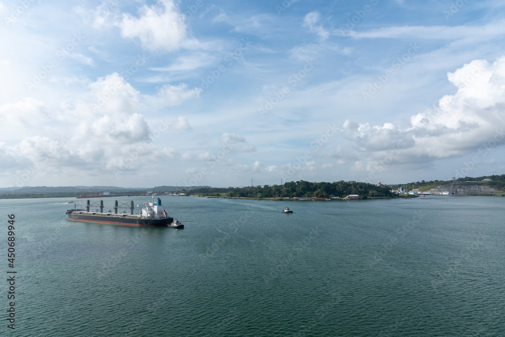 Landscape of Panama Canal, with cargo ship sailing through Gatun Lake on her way to the Pacific Ocean. 