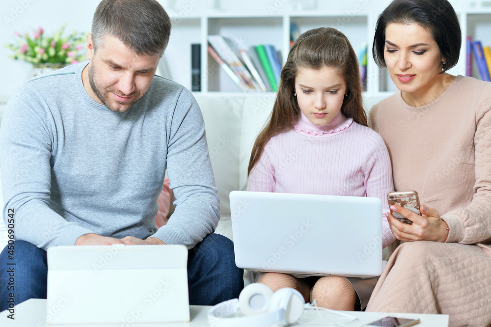 Happy parents and daughter using digital devices Happy parents and daughter using digital devices