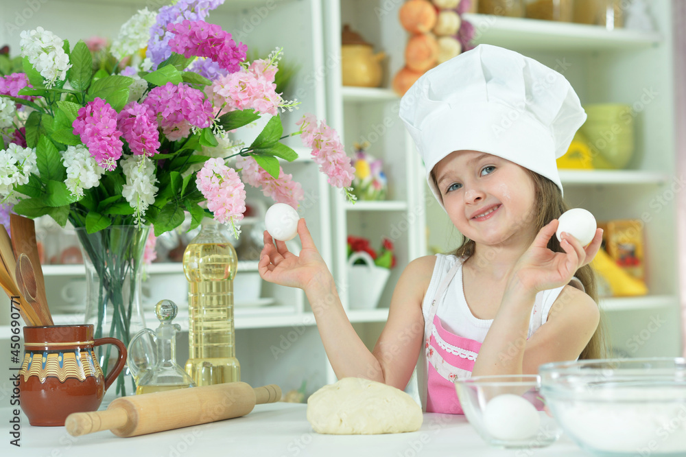 Cute girl in chefs hat making dough Cute girl in chefs hat making dough