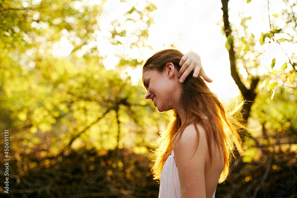 Woman in white dress straightens her hair outdoors green leaves nature Woman in white dress straightens her hair outdoors green leaves nature