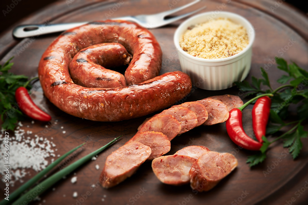 Linguiça calabresa assada e fatiada, sobre tábua de cortes com farofa Stock 写真 Adobe Stock