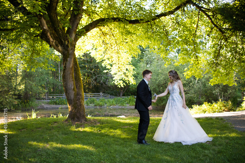 Young couple prepare to dance under large tree in nature. photo