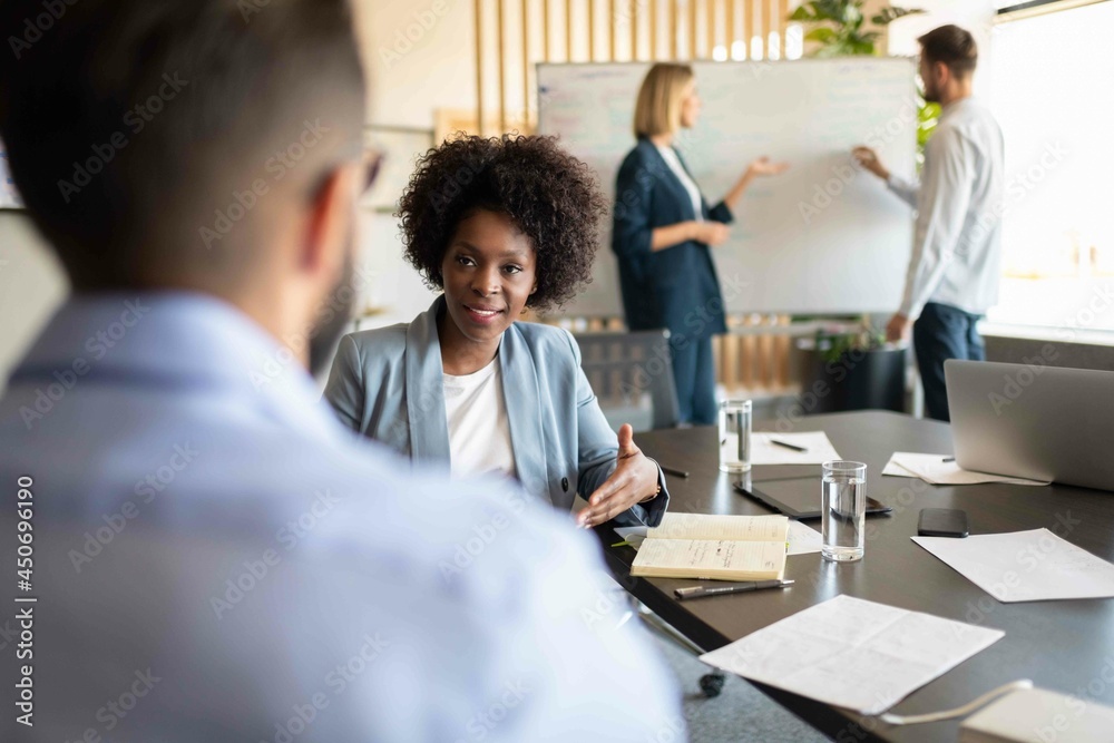 Black businesswoman speaking with colleague Black businesswoman speaking with colleague