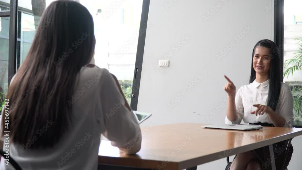 asian young business woman Job interviews or presentations in sign language . two female talking  by  show symbols with hands in meeting room at office.