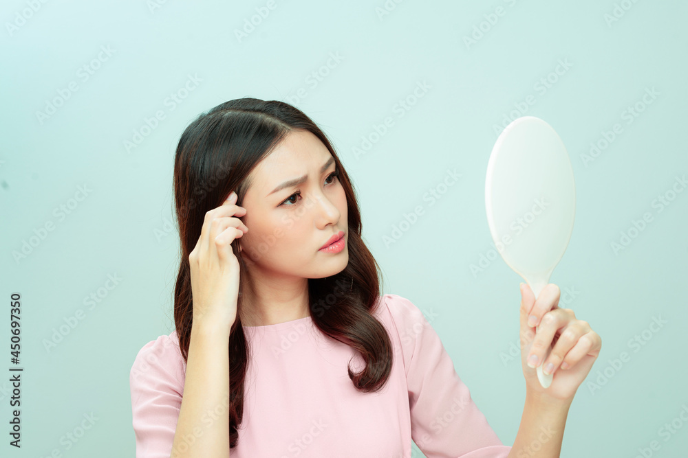 Woman looking at herself in a hand mirror Woman looking at herself in a hand mirror