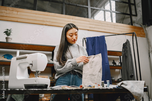 Professional young female tailor working in workshop