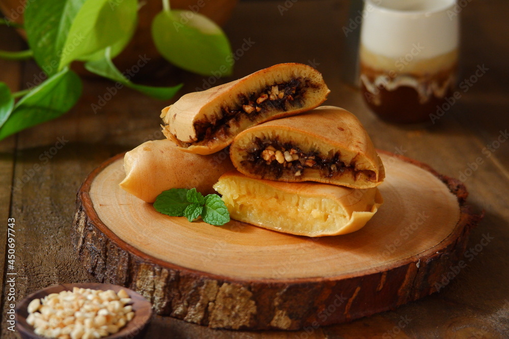 sweet pancake named martabak manis in a wooden coaster sweet pancake named martabak manis in a wooden coaster