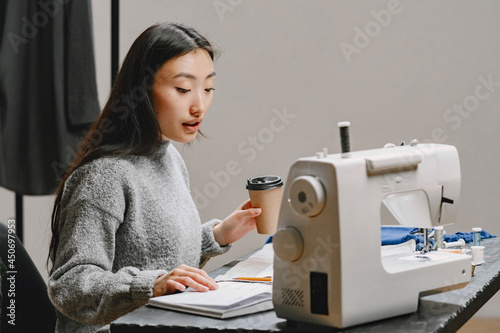 Professional young female tailor working in workshop