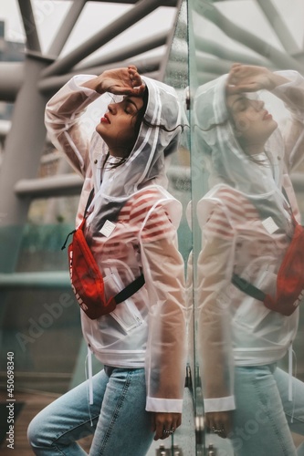 girl in the rain in a raincoat. Drops on glass.