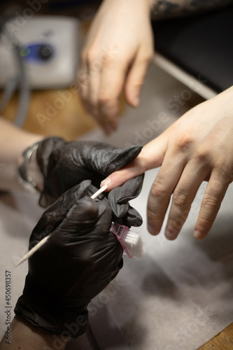 Men s manicure. Professional manicure for man by manicure machine. A man receiving a manicure in the beauty salon. Beautician master trimming and removes cuticles.