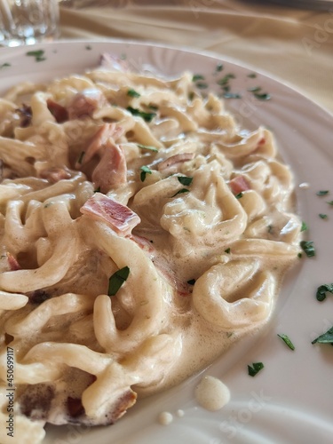 strozzapreti, italian fresh pasta with mushrooms, bacon and cream, dumplings with mushrooms