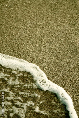 Sea wave on the sand. Space for text. Texture effect