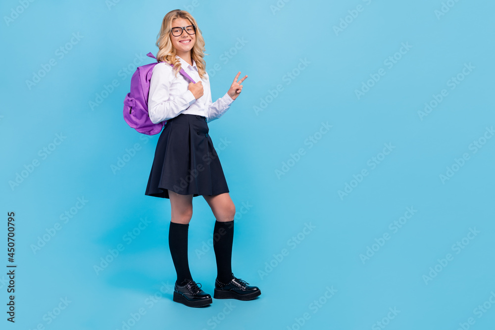Photo of cute blonde schoolgirl show v-sign wear eyeglasses white shirt skirt isolated blue color background Photo of cute blonde schoolgirl show v-sign wear eyeglasses white shirt skirt isolated blue color background