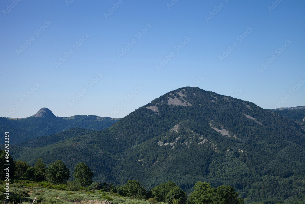 Paysage de montagne d'Ardèche avec le suc de Sara au premier plan et le mont Gerbier de Joncs dans le lointain