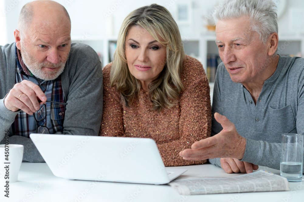two senior men and woman sitting at table two senior men and woman sitting at table