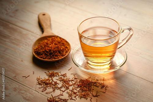 Bilde på lerret Cup of herbal tea with dried herb (lotus stamen) on wooden plate background