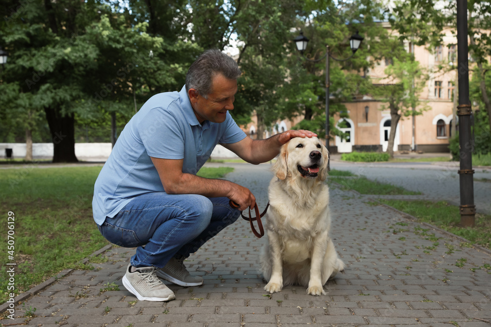 Happy senior man with his Golden Retriever dog in park Happy senior man with his Golden Retriever dog in park