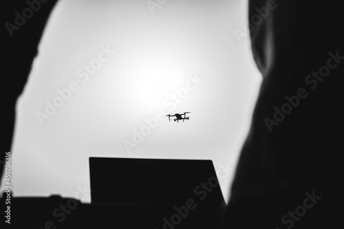 Fotografie Silhouette of drone pilot flying with quadcopter outdoors at sunset - Drone pilo