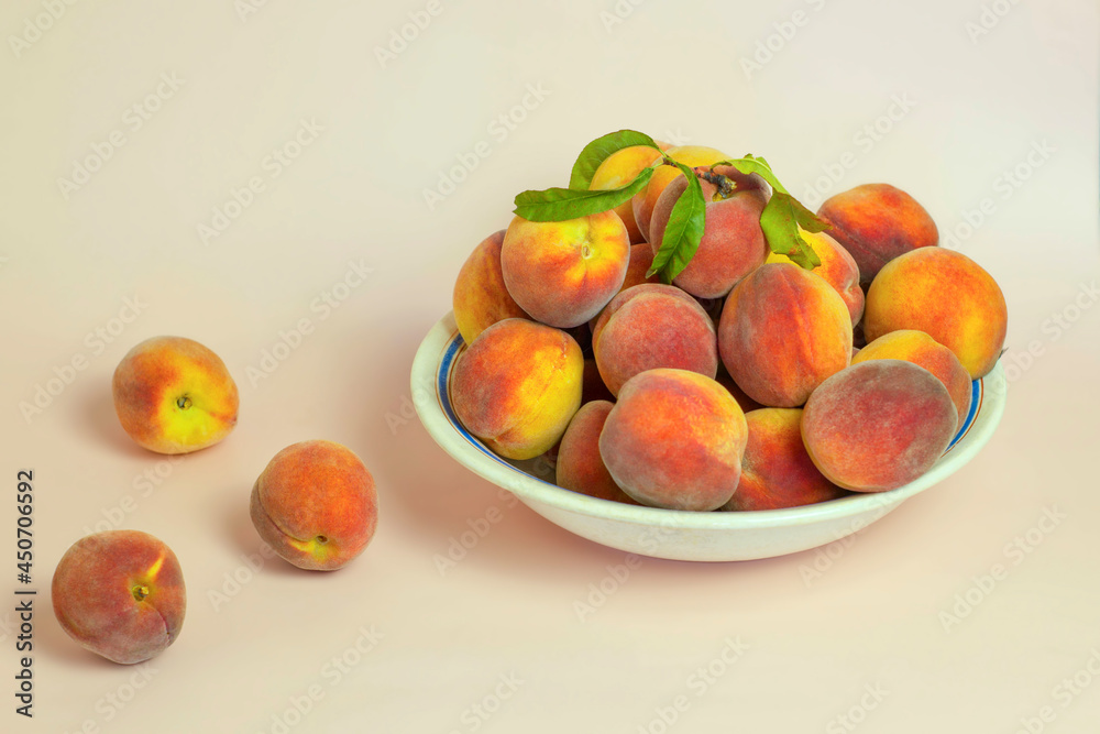 Plate with fresh peaches on pastel background Plate with fresh peaches on pastel background