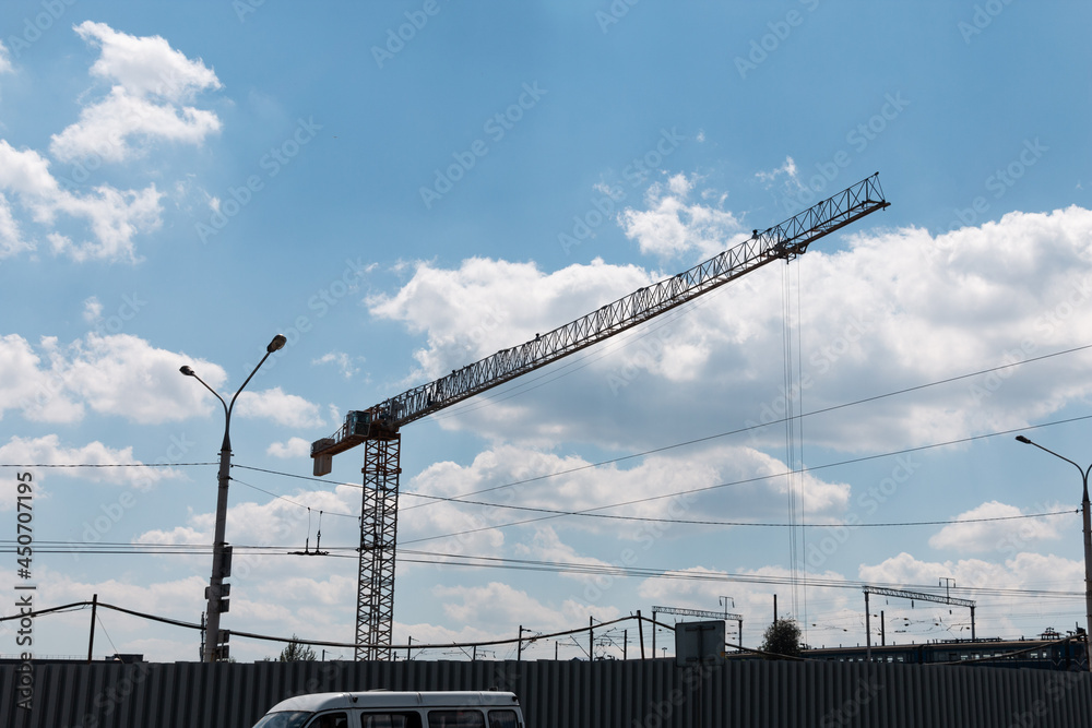 Construction crane on a construction site against the blue sky. Construction crane on a construction site against the blue sky.