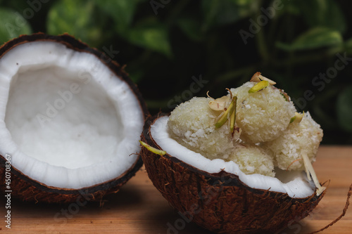 close up of Popular Indian sweet Kopara pak or Coconut barfi made up of Coconut, Milk and Sugar in coconut bowl photo