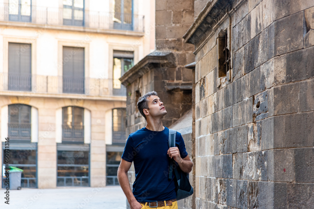 Young latin tourist man visiting the city with his bag
