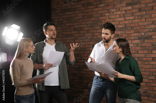 Professional actors reading their scripts during rehearsal in theatre photo