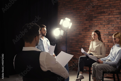 Professional actors reading their scripts during rehearsal in theatre