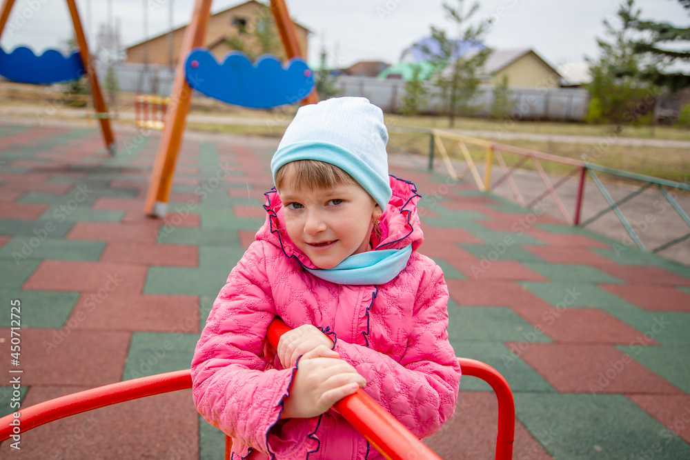 happy girl on the carousel with blurred background from behind gives dynamics to the picture