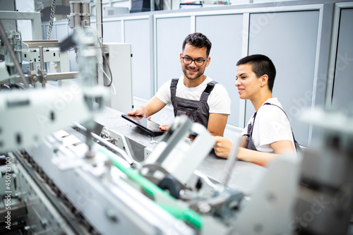 Konstfotografi Experienced serviceman controlling process and servicing modern industrial manufacturing machine in production factory
