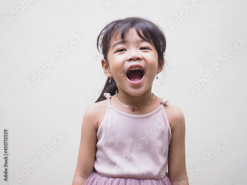 Beautiful Asian kid girl from Indonesia showing happiness expression with mouth open. Isolated on white photo