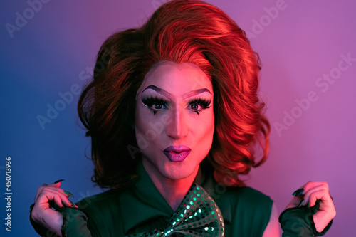 Portrait of drag queen on colored background looking into the camera