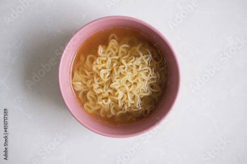 Noodle soup in a bowl. Top view isolated on white photo