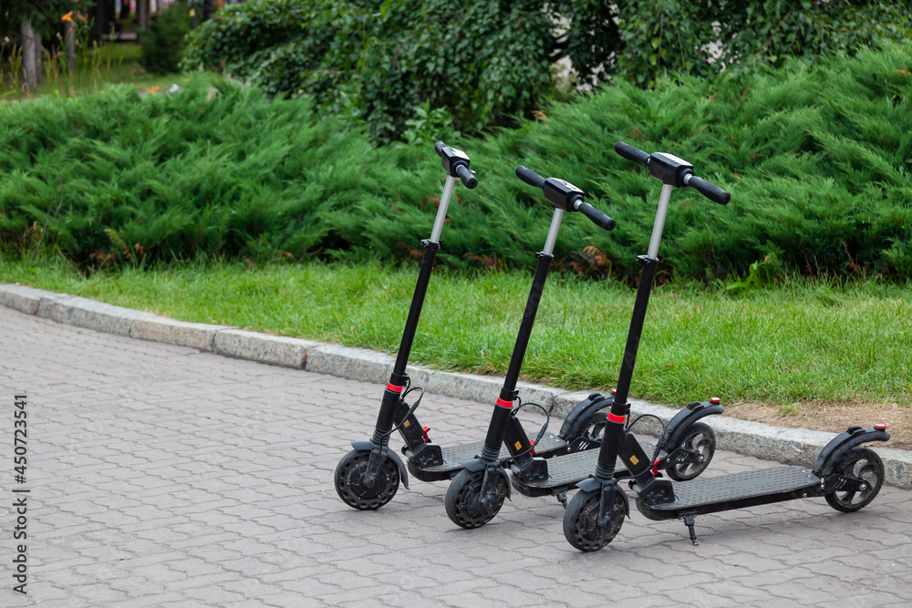 Electric scooters in row on the parking lot City bike rental system, public kick scooters on the street electric scooter in Novosibirsk, Russia