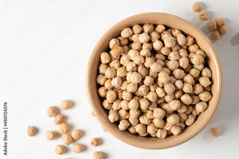 dry chickpeas, in a ceramic dish on a white table, top view, close-up dry chickpeas, in a ceramic dish on a white table, top view, close-up
