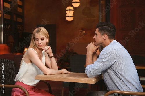 Bored couple having unsuccessful date in cafe