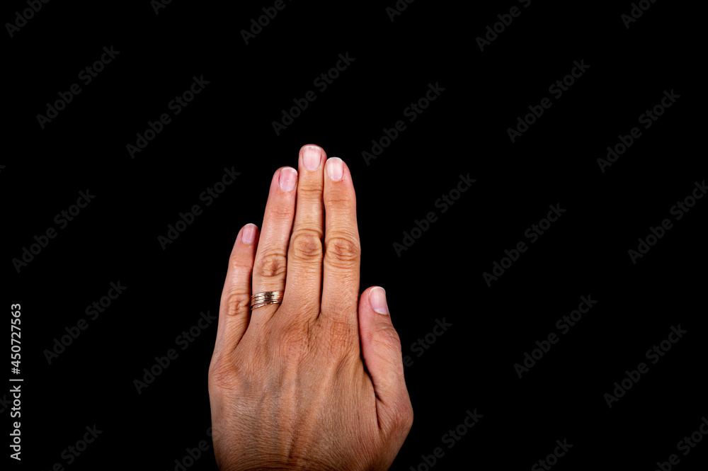 Fototapeta premium Close view of a woman hand with nails on white spots, missing vitamins, calcium on black background.