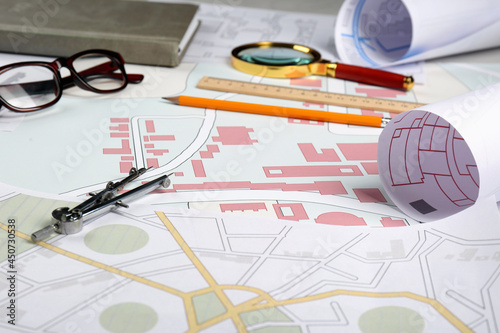 Office stationery and eyeglasses on cadastral maps of territory with buildings photo
